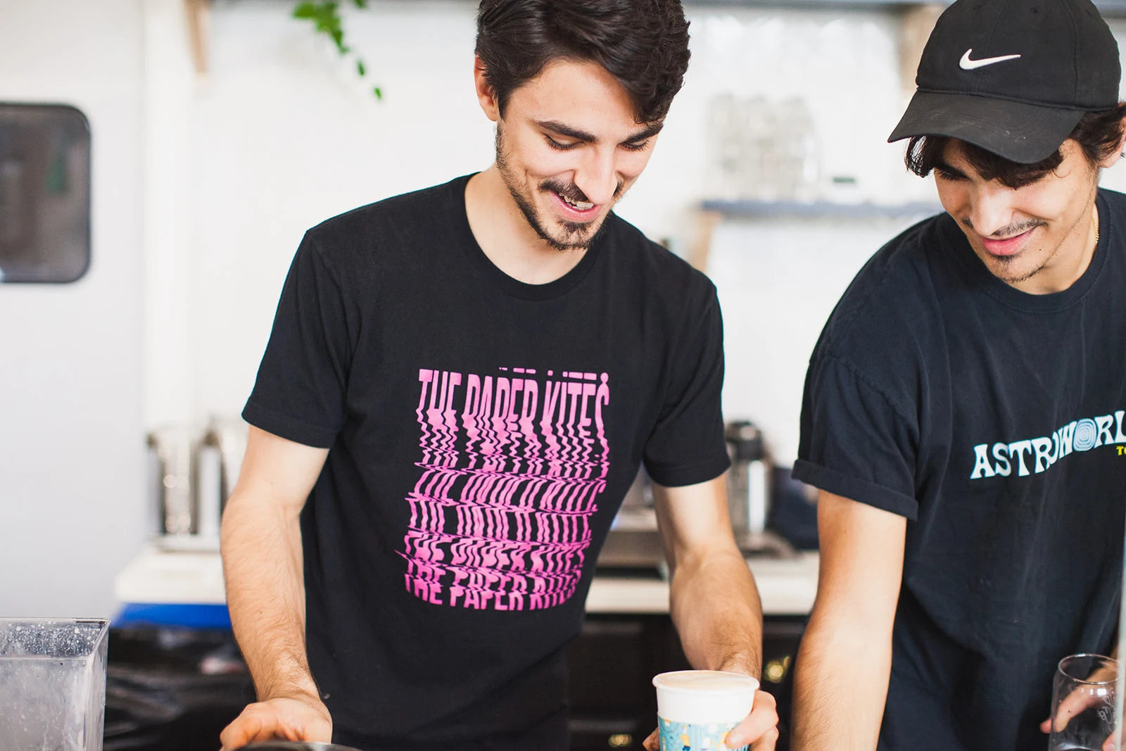 Two Wake Up baristas laughing together behind the counter