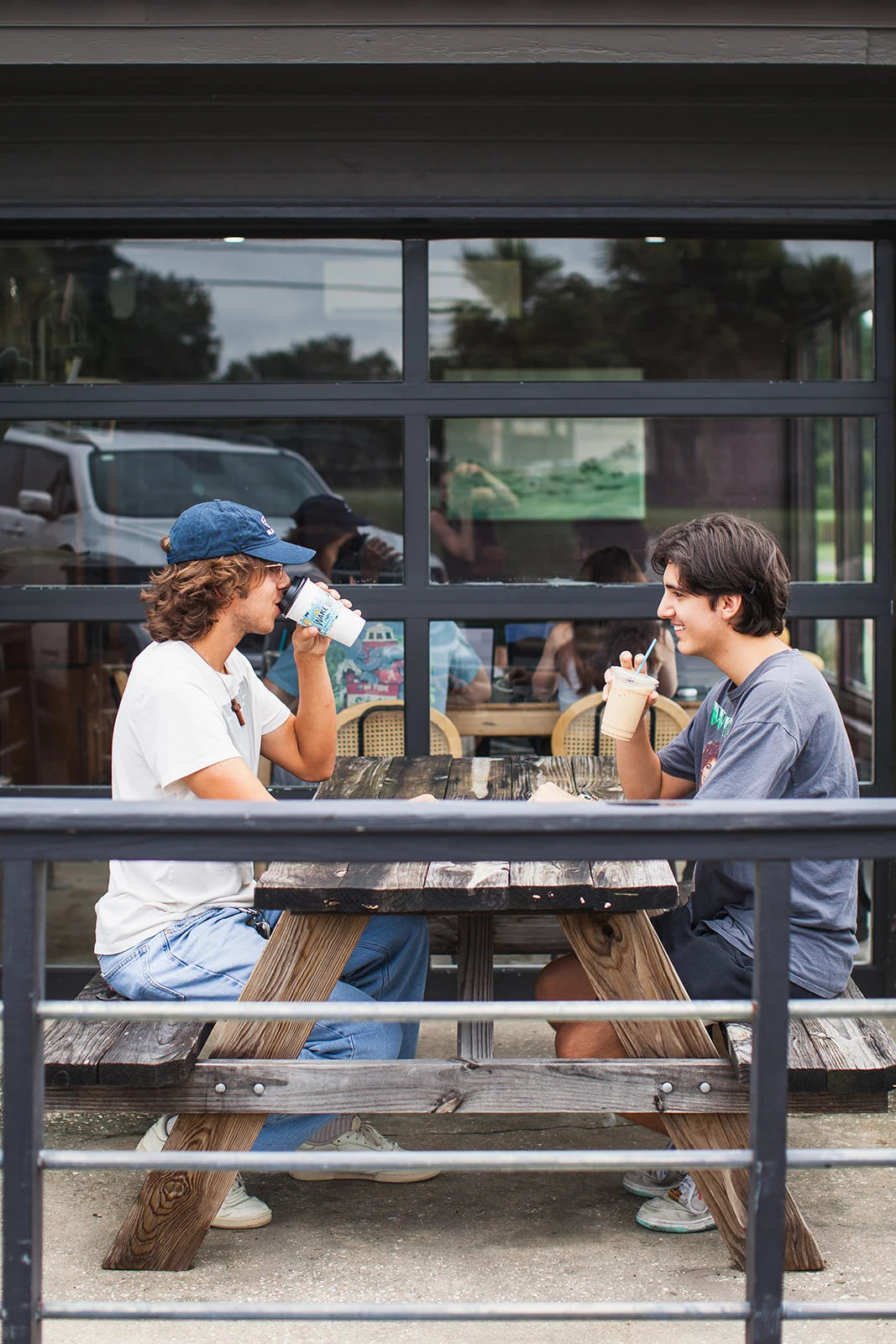 Friends sharing coffee at a Wake Up café patio table